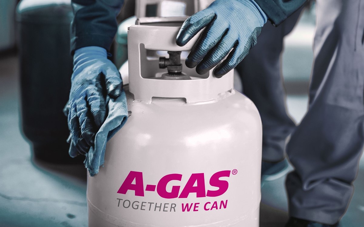 engineer with blue gloves handling and cleaning A-Gas branded gas cylinder
