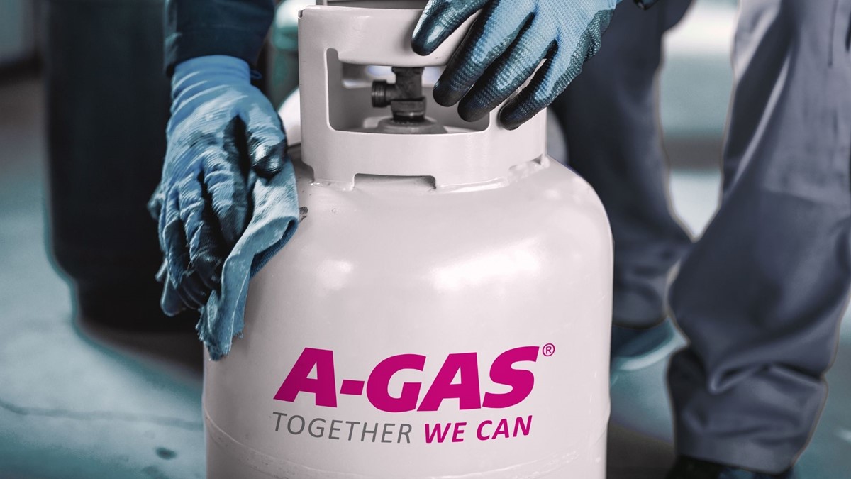 engineer with blue gloves handling and cleaning A-Gas branded gas cylinder