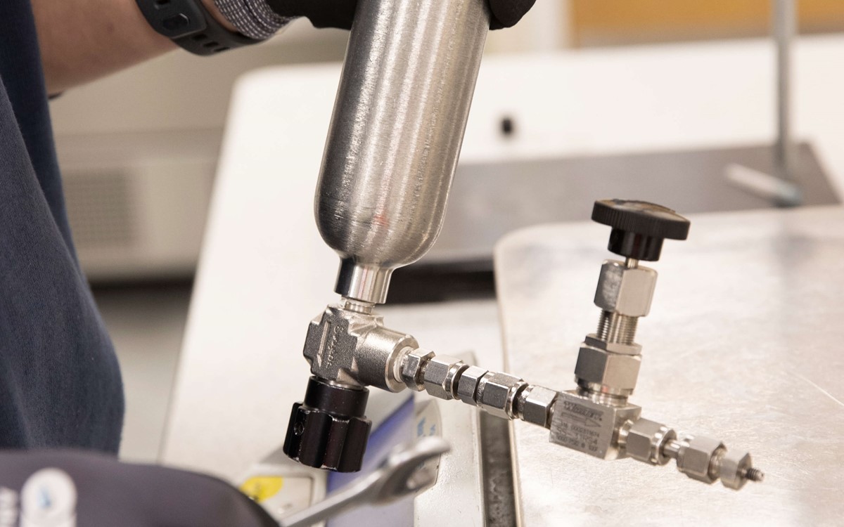 close up of hand holding a cylinder in a lab