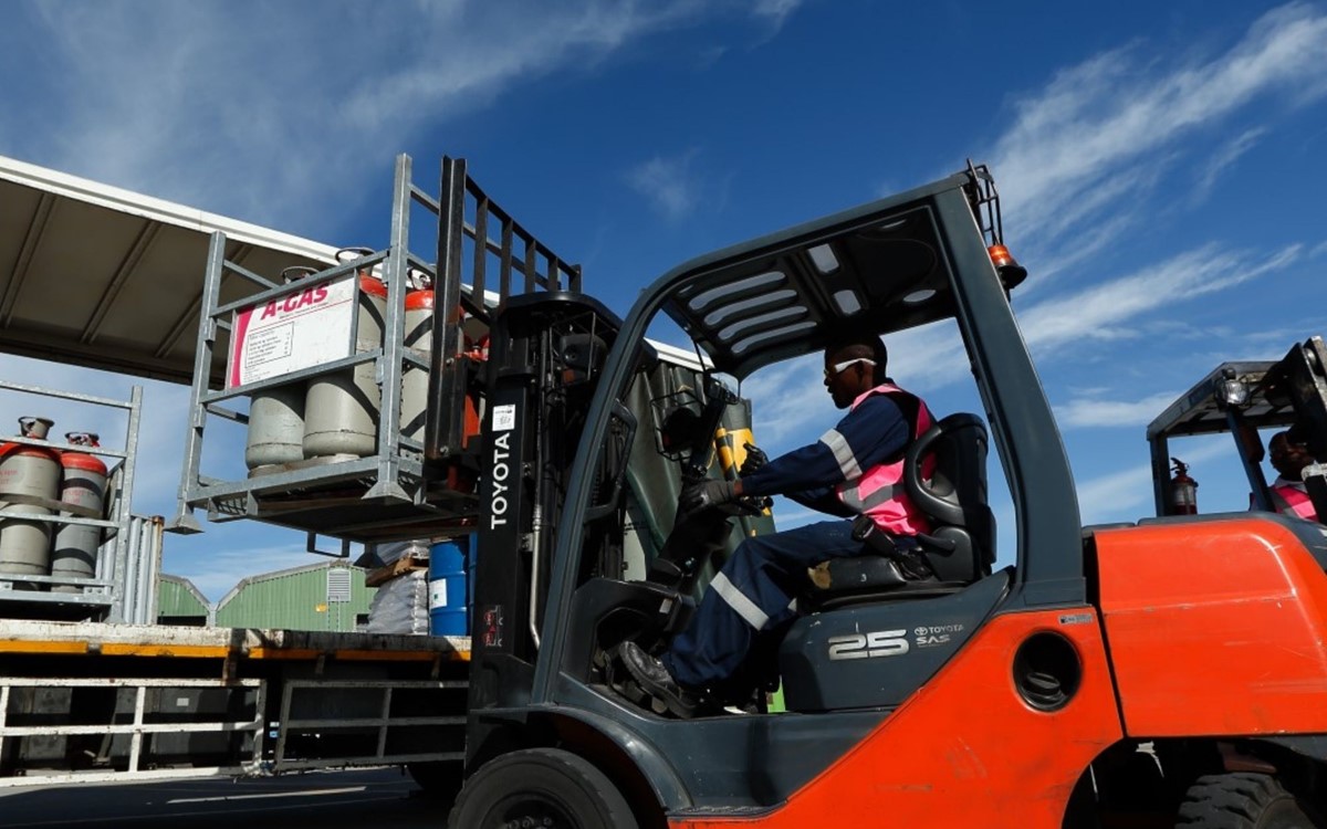 A forklift truck loading cylinders onto a lorry