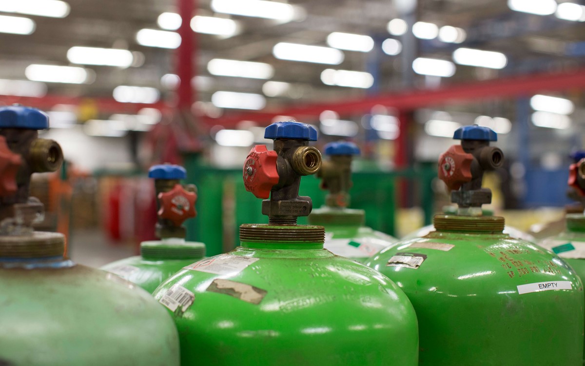 Green industrial cylinders lined up next to each other