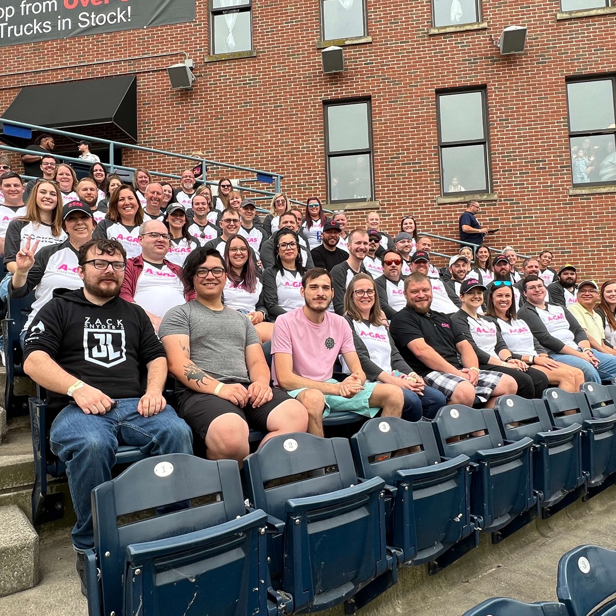 A group of people sat in the stands at a sports game