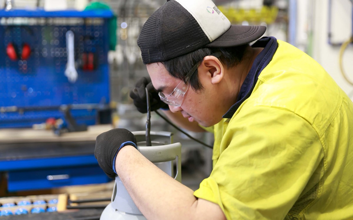 Close up of a warehouse technician working on a cylinder